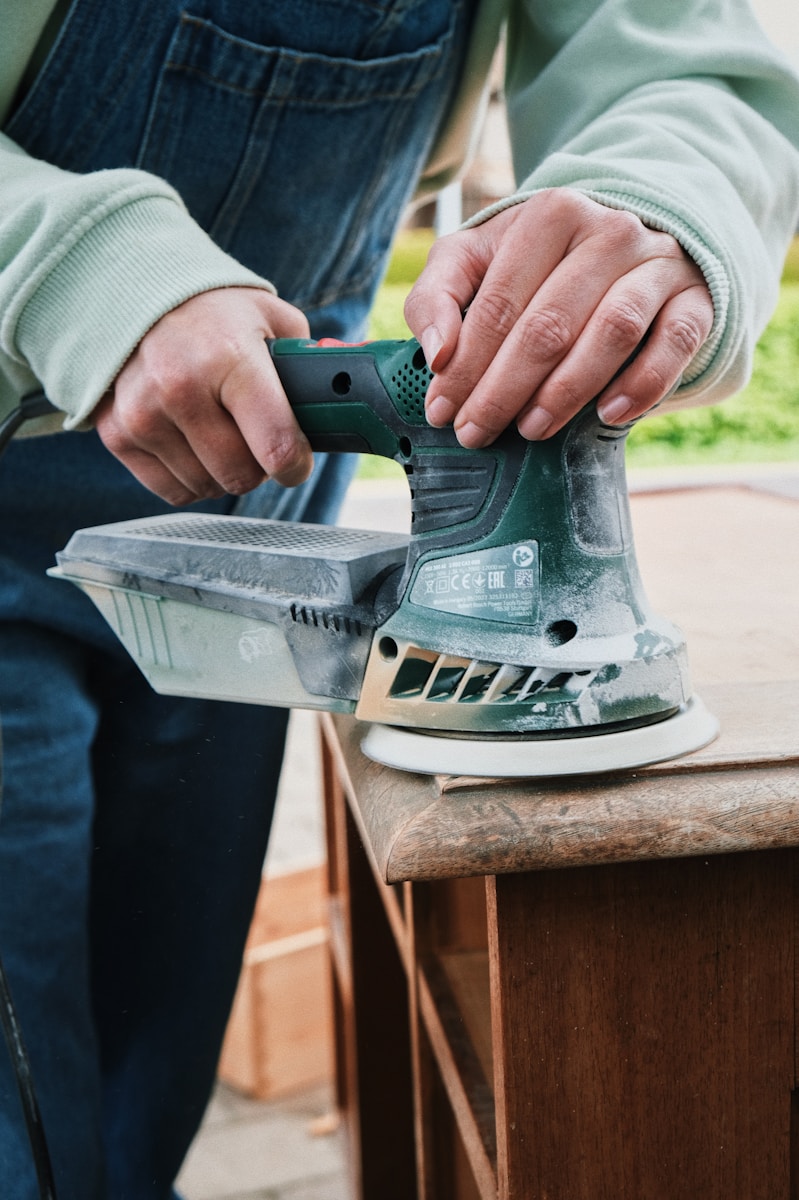 a person using a sander on a wooden table