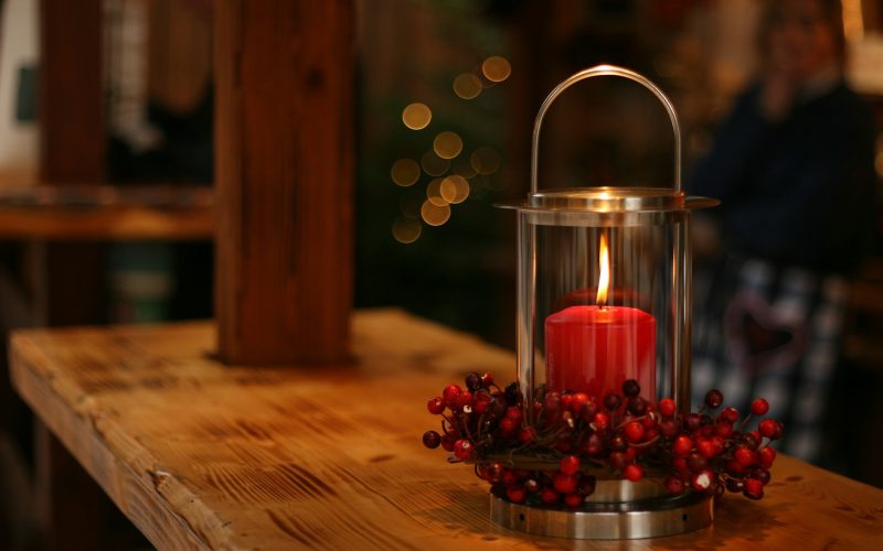 red lighted candle on brown wooden frame
