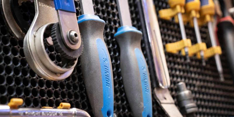 A bunch of tools are hanging on a wall
